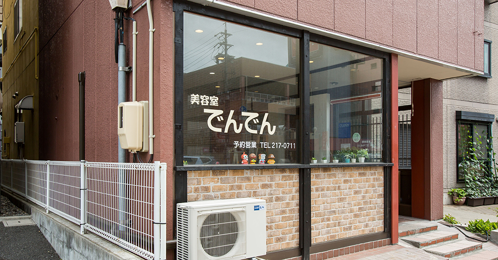 紙片コラージュのようなやわらかな雰囲気で撮影した美容室の受付まわり、丸みのある小物と木製カウンターが見える店内写真